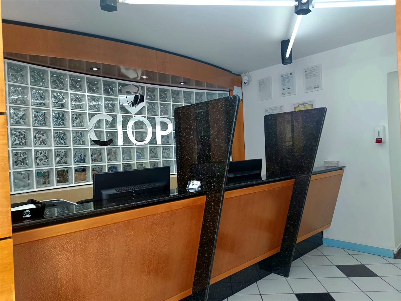 Recepção com o nome CIOP na parede de tijolos de vidro